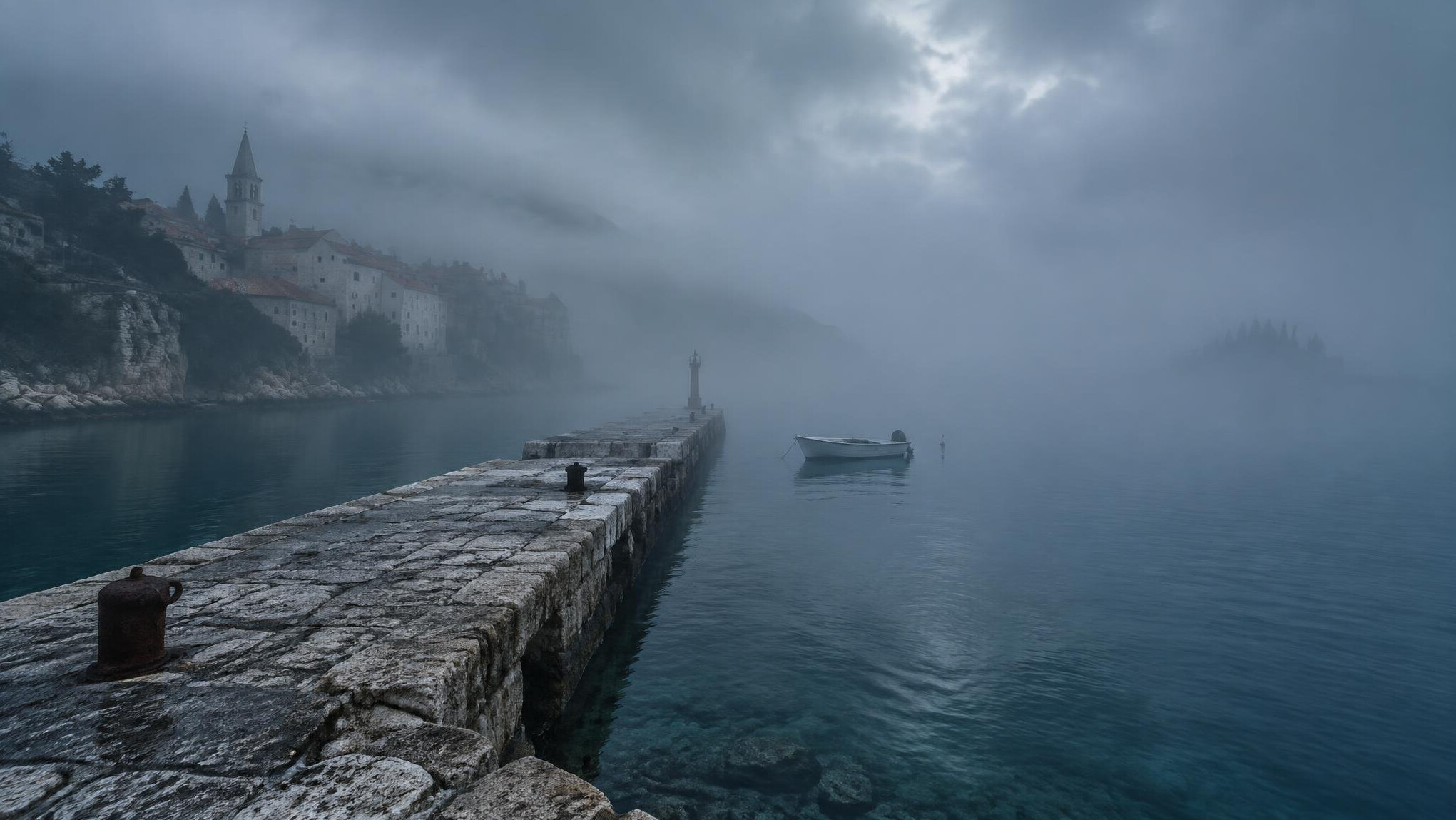 Foggy Adriatic coastline with an old stone pier